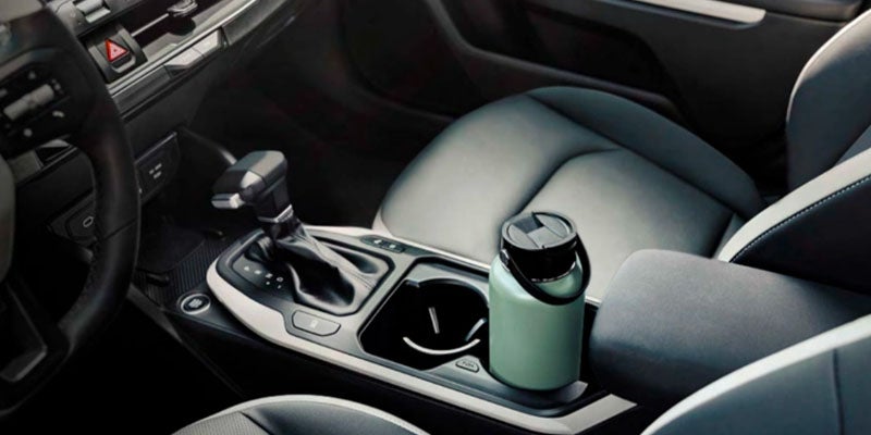 Center console of the Kia K4 with cup holders and gear shifter designed for passenger comfort
