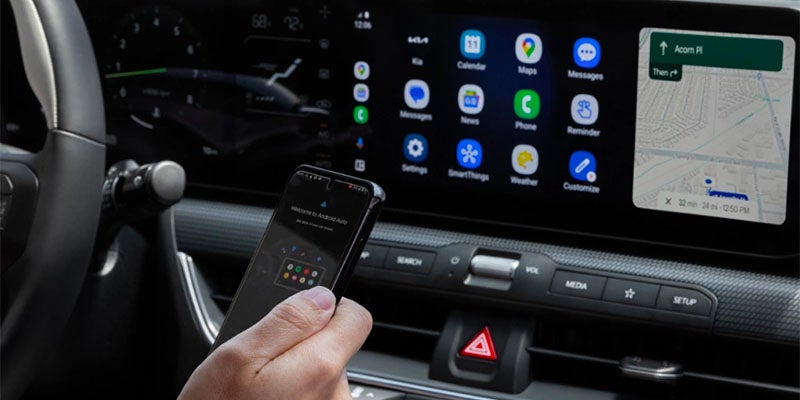 Close-up of the Kia K4 infotainment screen with smartphone connectivity and navigation features
