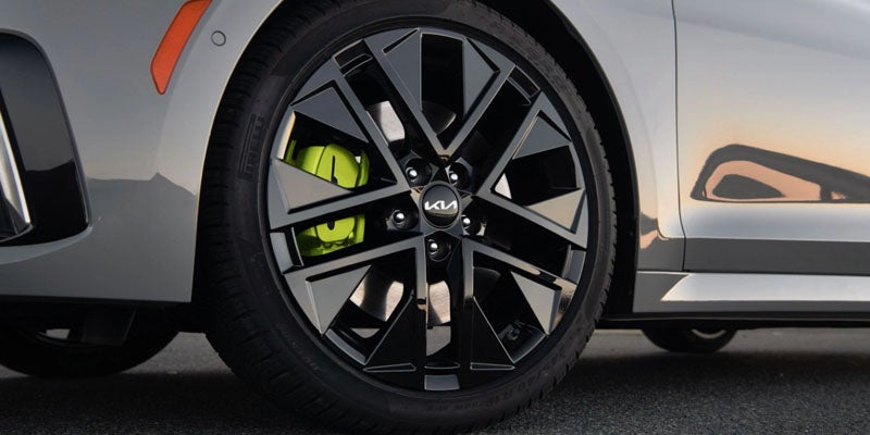 Close-up of the Kia K5 alloy wheel with sporty green brake calipers.