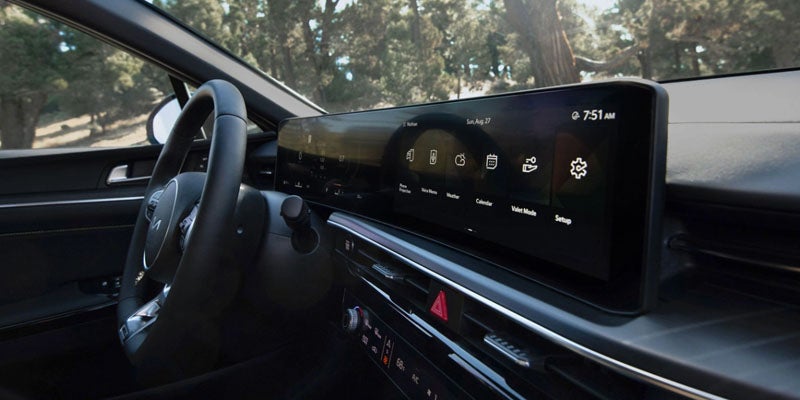 Interior view of the Kia K5 digital infotainment display with navigation and apps.
