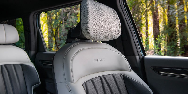 The interior of a car, showing the white and gray front seats.