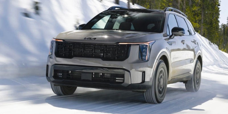A gray SUV drives on a snowy road