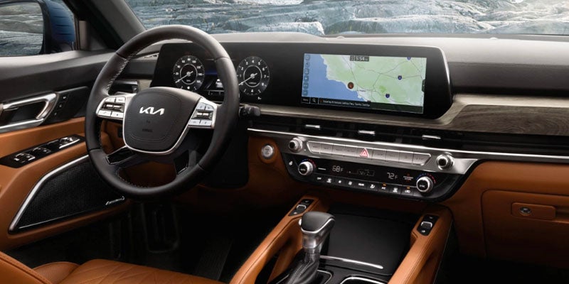 The steering wheel and dashboard of a brown and black Kia Telluride