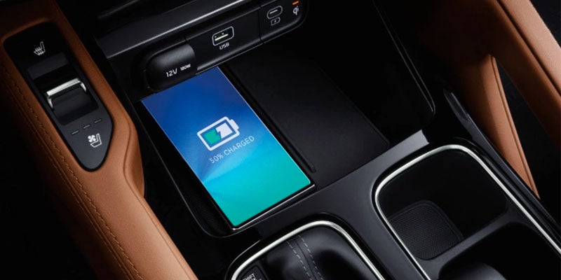 A smartphone on the wireless charging pad in a Kia